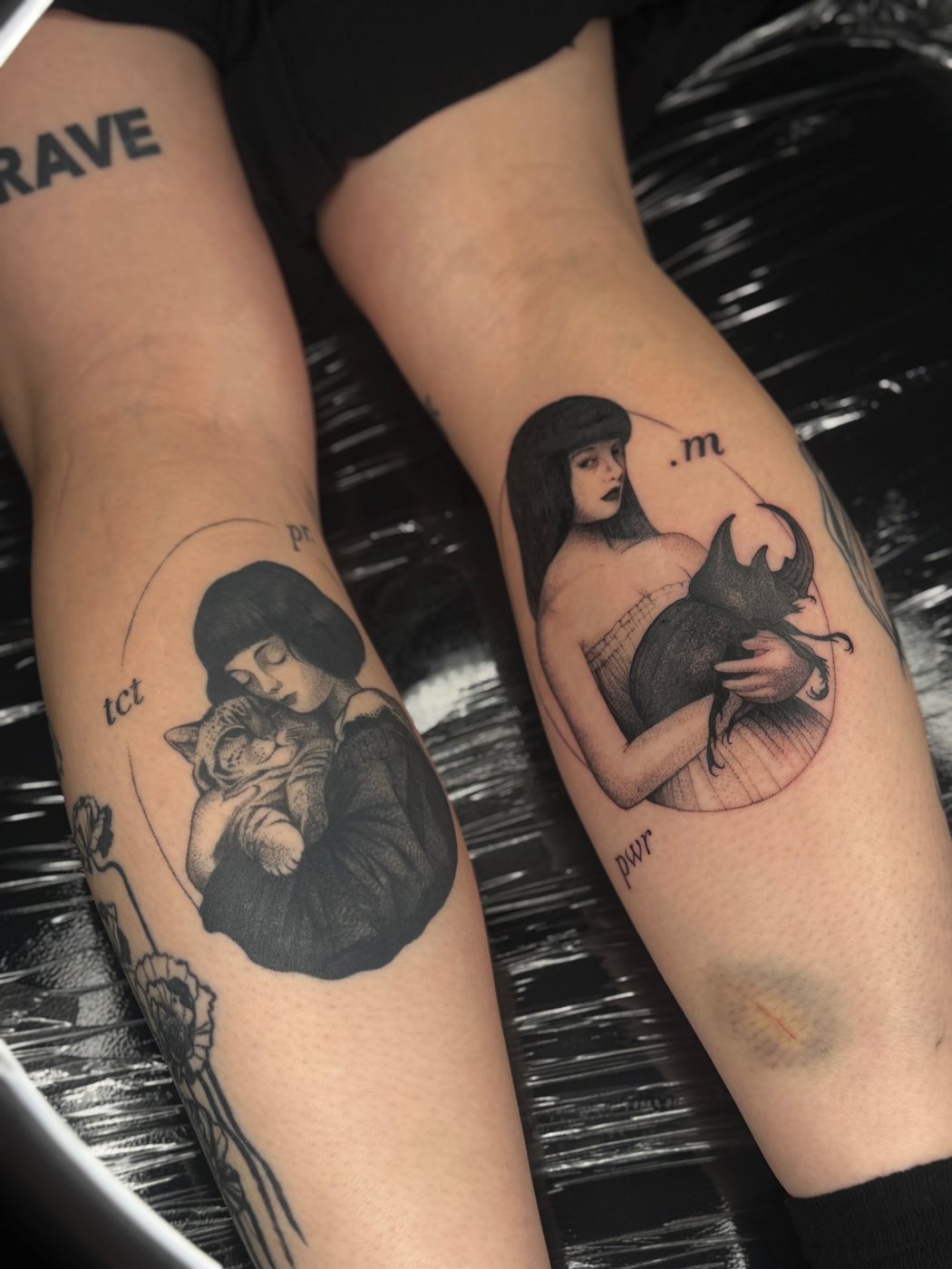 Surreale Tattoos auf zwei Waden: Frau umarmt eine Katze, Frau hält einen Nashornkäfer – gestochen von Florian Rudolph in Berlin