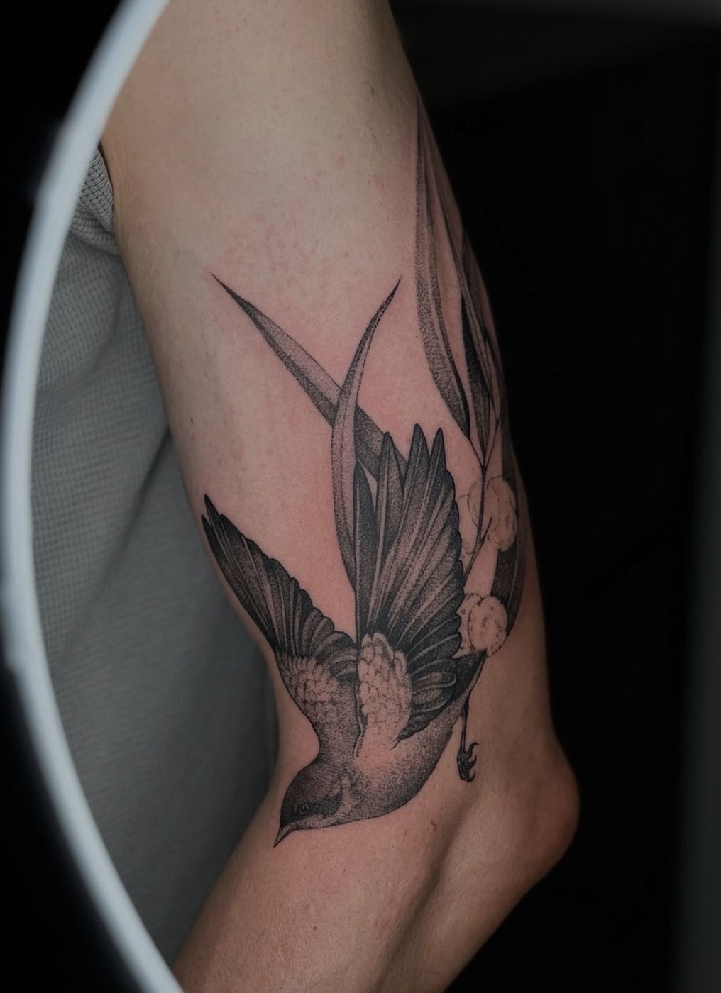 Surreales Tattoo am Unterarm: Schwalbe mit Pflanzenblättern als Schwanzfedern – gestochen von Florian Rudolph in Berlin