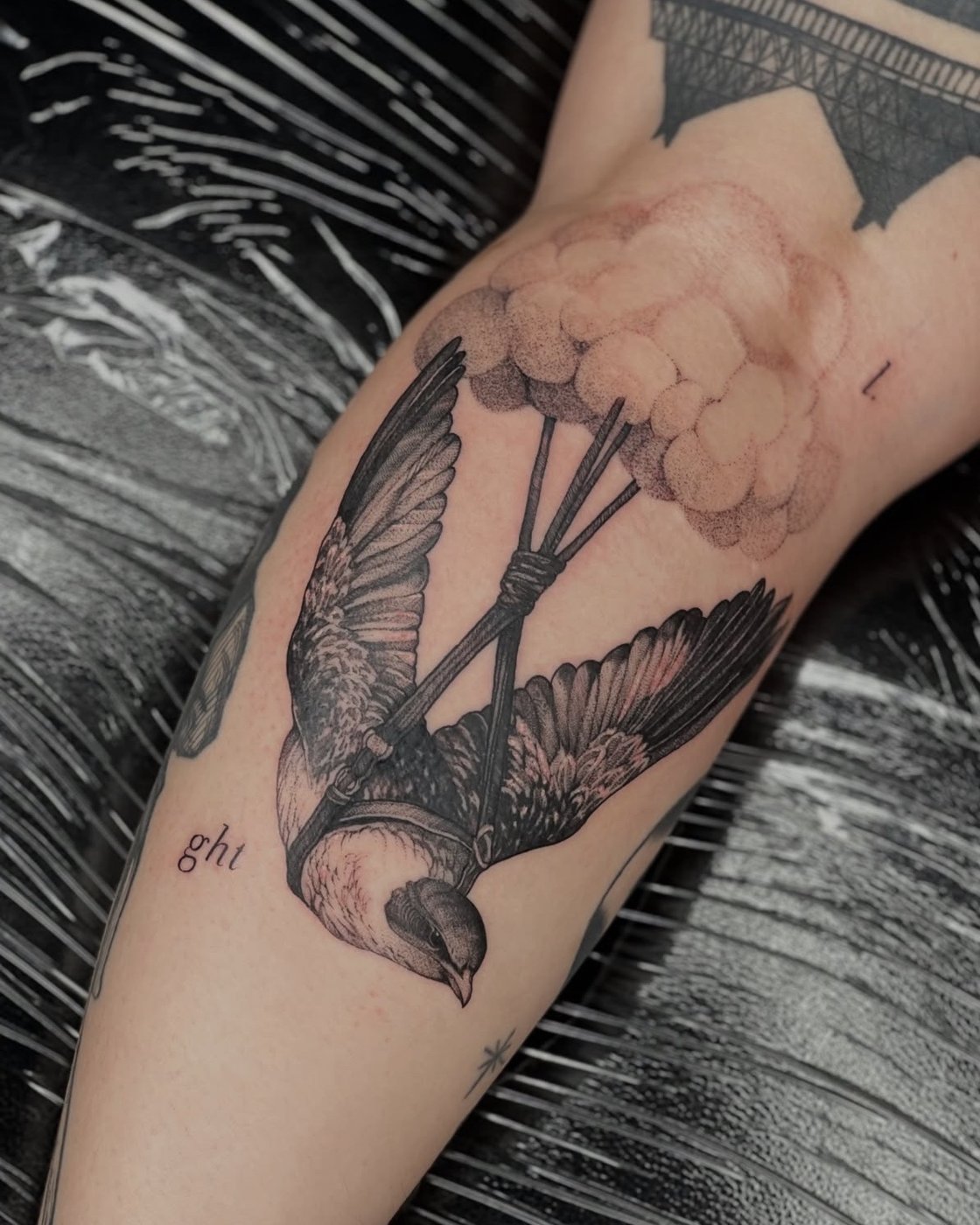 Surreales Tattoo am Oberschenkel: Vogel, der an einer Wolke hängt – gestochen von Florian Rudolph in Berlin