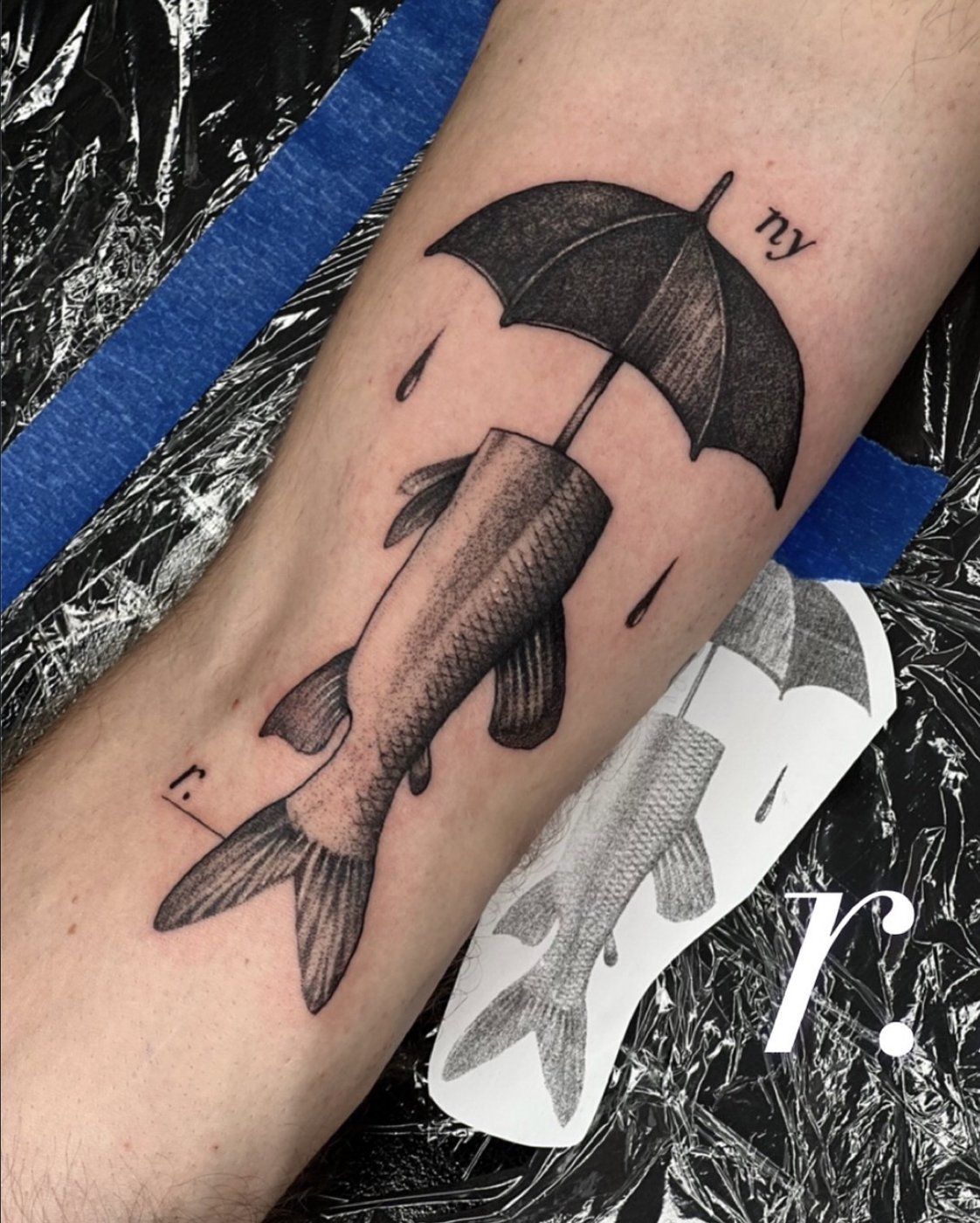 Surreales Tattoo am Unterarm: Fisch mit Regenschirm – gestochen von Florian Rudolph in Berlin